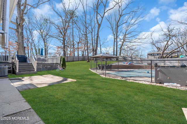 view of yard featuring a fenced in pool, a gazebo, a fenced backyard, a deck, and a patio