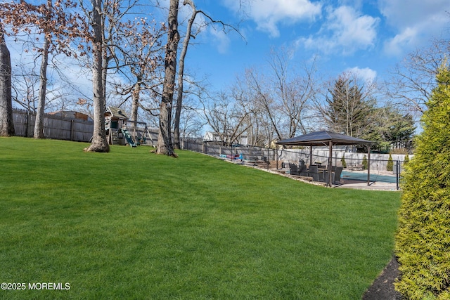 view of yard featuring a gazebo, a playground, and a fenced backyard