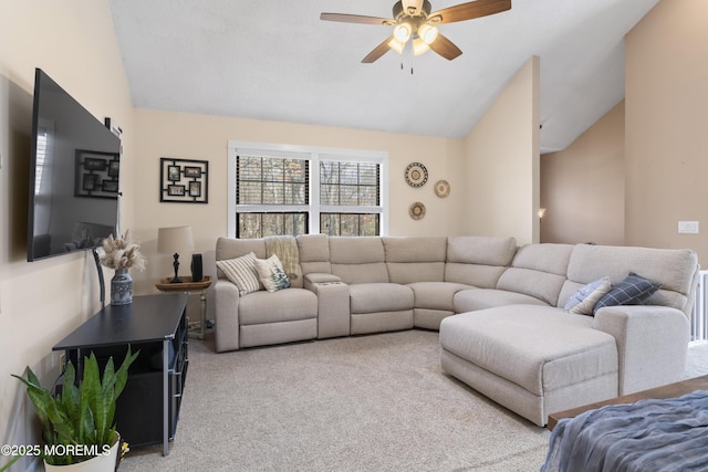 living area featuring a ceiling fan, lofted ceiling, and light colored carpet