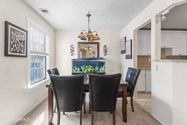 dining area with visible vents, light carpet, a textured ceiling, baseboards, and a chandelier