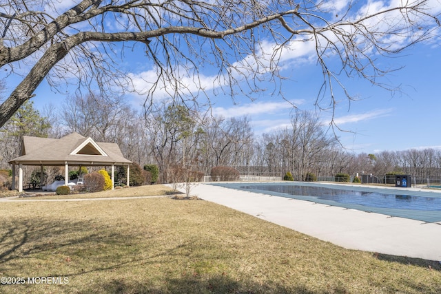 community pool featuring a patio, a lawn, and fence