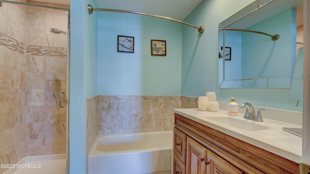 bathroom featuring vanity, a shower stall, and a garden tub