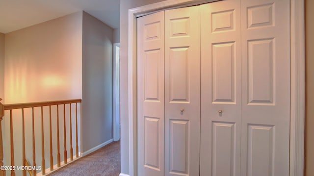 hall with baseboards and carpet floors