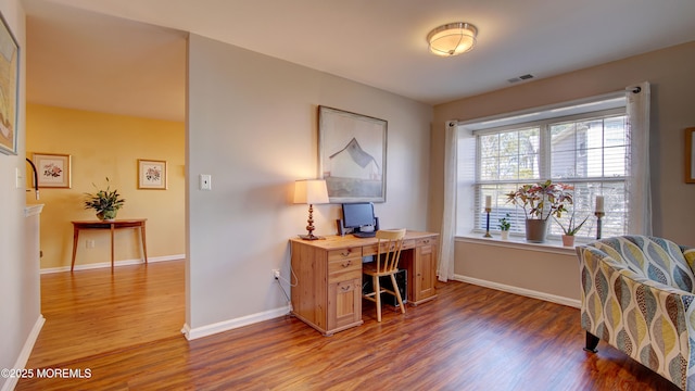 home office featuring wood finished floors, visible vents, and baseboards