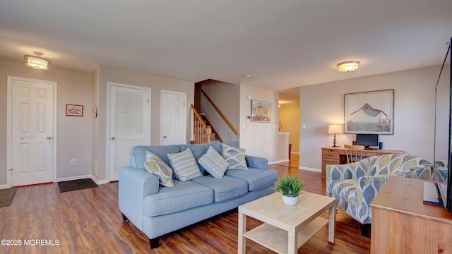 living area with stairway, baseboards, and wood finished floors