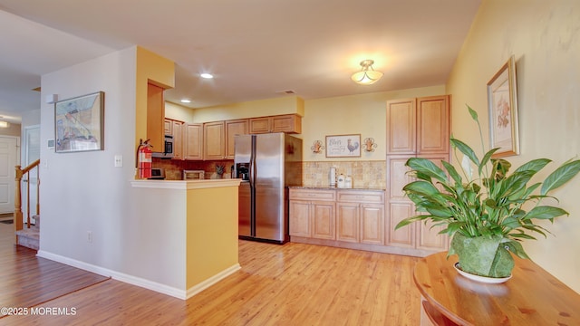 kitchen featuring tasteful backsplash, baseboards, light countertops, light wood-type flooring, and appliances with stainless steel finishes