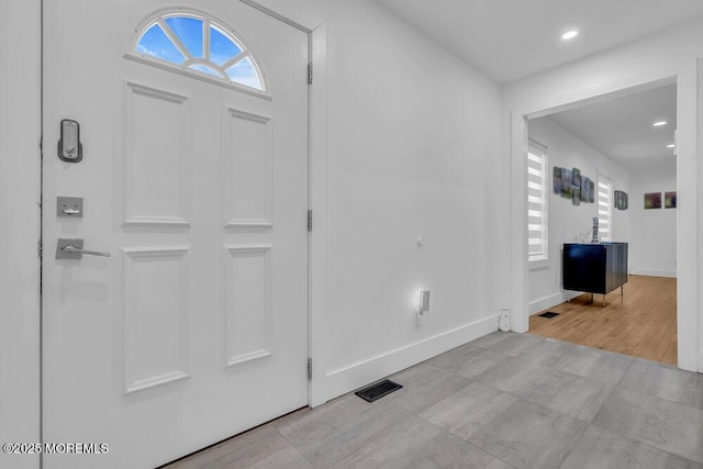 foyer with visible vents, recessed lighting, and baseboards