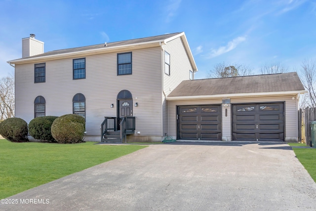 view of front facade with a front lawn, a chimney, driveway, and a garage