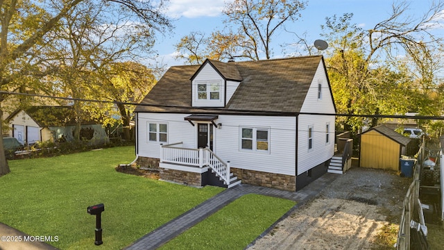 view of front of home with a storage unit, driveway, an outdoor structure, and a front lawn