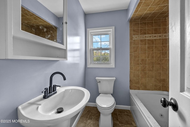 bathroom featuring tile patterned floors, toilet, baseboards, and a sink