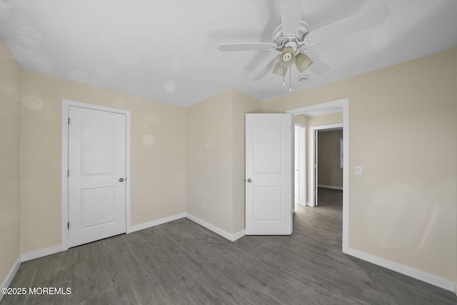 unfurnished room featuring a ceiling fan, baseboards, and wood finished floors