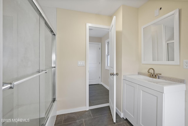 full bath with vanity, baseboards, and a shower with door