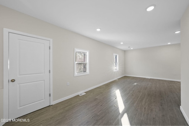 empty room with visible vents, recessed lighting, wood finished floors, and baseboards