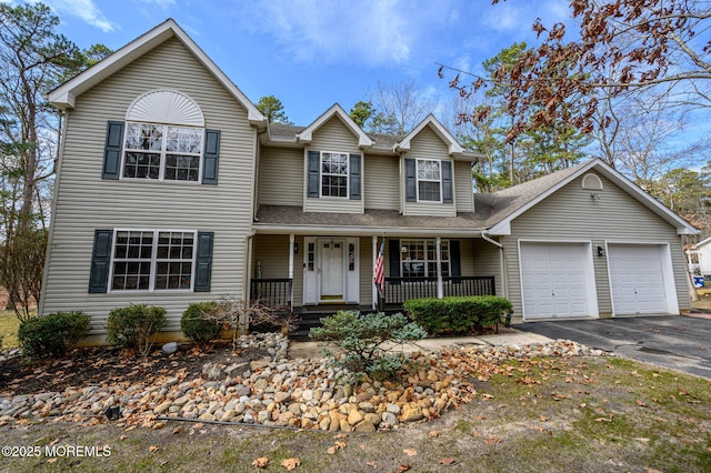 traditional-style home featuring aphalt driveway, a porch, an attached garage, and roof with shingles