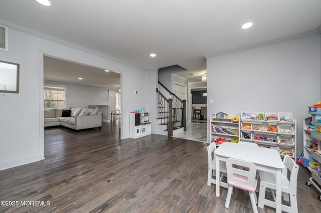 recreation room with wood finished floors and crown molding