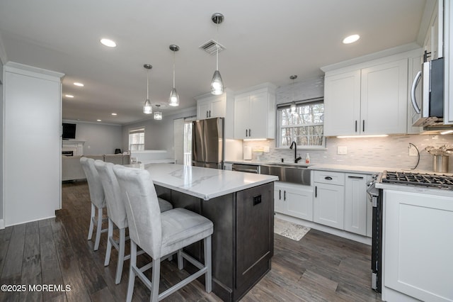 kitchen featuring plenty of natural light, open floor plan, appliances with stainless steel finishes, and a sink