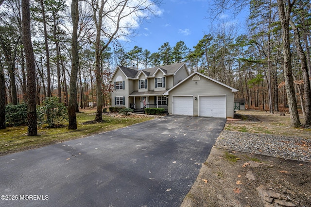 traditional-style house featuring an attached garage and driveway