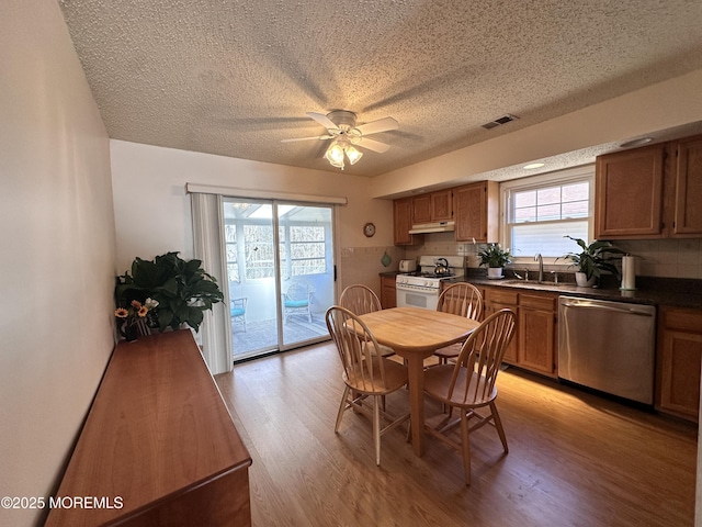 dining room with visible vents, a healthy amount of sunlight, light wood-type flooring, and ceiling fan