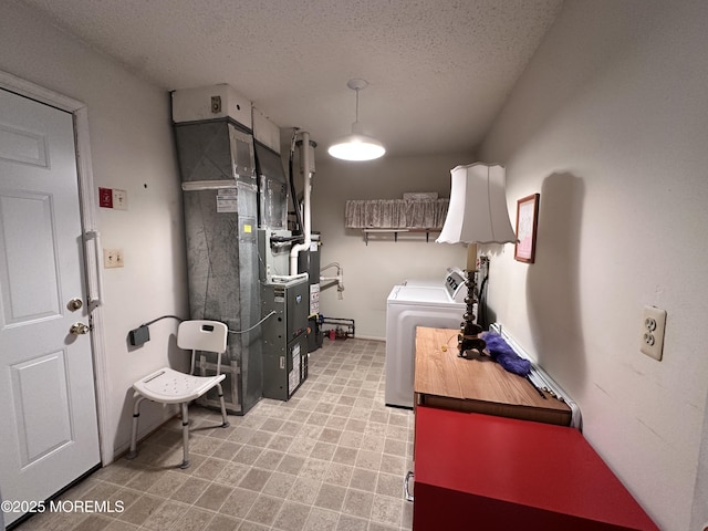 washroom with heating unit, laundry area, independent washer and dryer, and a textured ceiling