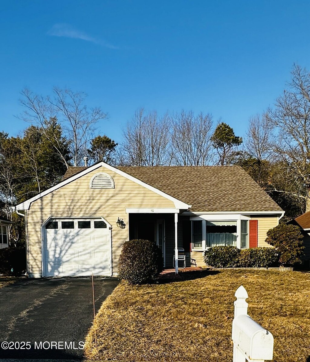 10 Deer Run Ln, Brick, NJ 08724 - view of front of house featuring a front yard, an attached garage, driveway, and roof with shingles