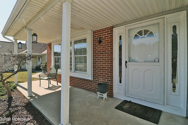 entrance to property with brick siding and covered porch