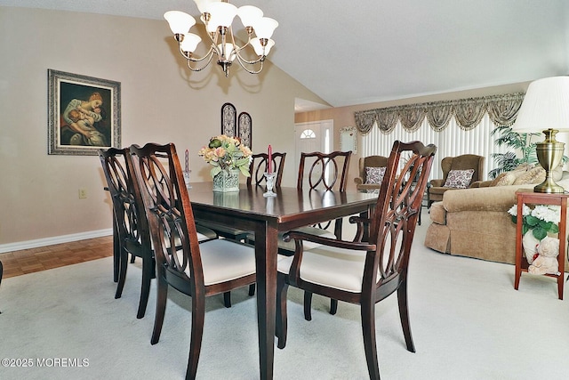 dining space featuring baseboards, a notable chandelier, and vaulted ceiling