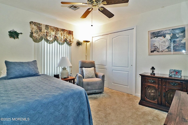 bedroom featuring visible vents, light colored carpet, a closet, and ceiling fan