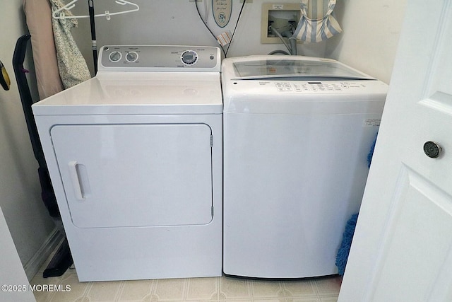 laundry area with separate washer and dryer, light floors, and laundry area