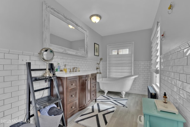 bathroom with a soaking tub, tile walls, wainscoting, and radiator heating unit