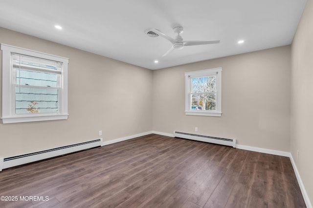 unfurnished room with ceiling fan, a baseboard heating unit, baseboards, and wood finished floors