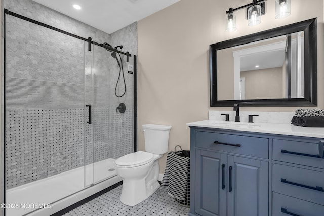 bathroom featuring toilet, a stall shower, and vanity