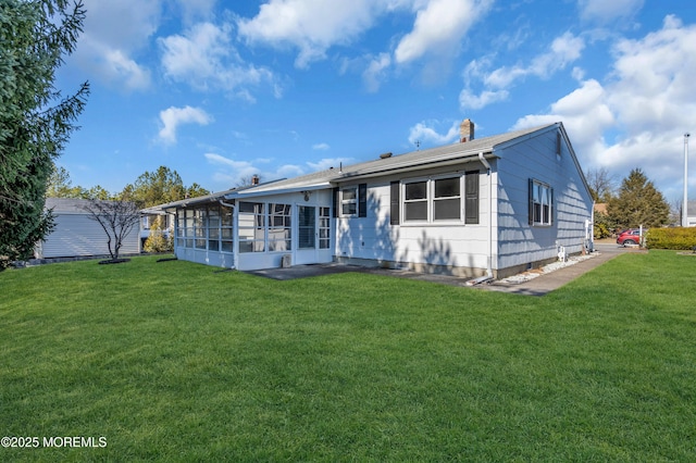 rear view of house featuring a lawn and a sunroom