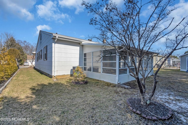 exterior space featuring a yard and a sunroom