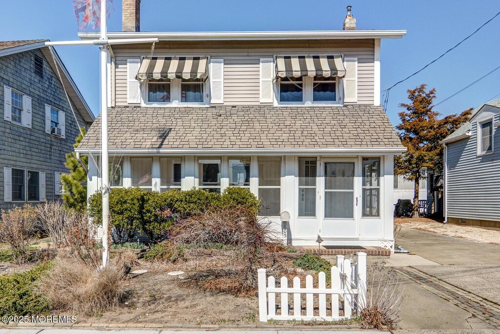 view of front facade featuring a chimney and fence