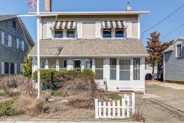 view of front facade featuring a chimney and fence