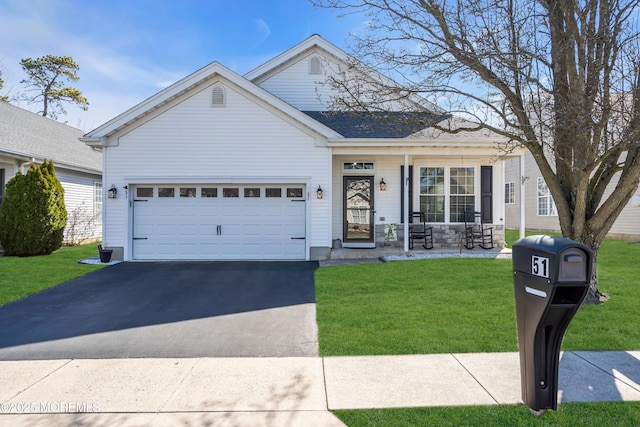 view of front of house with a front lawn, covered porch, a garage, and driveway