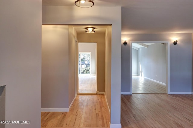 hall featuring wood finished floors and baseboards