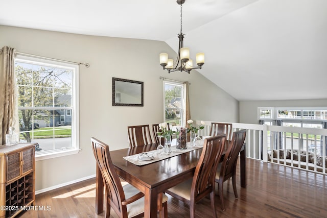 dining space featuring baseboards, vaulted ceiling, wood finished floors, and a notable chandelier