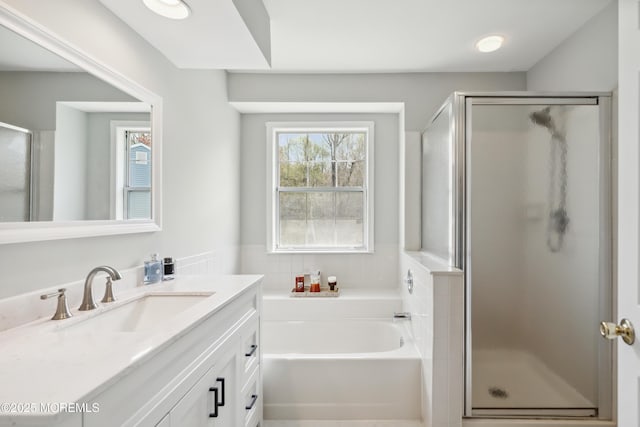 full bathroom with a shower stall, a garden tub, and vanity