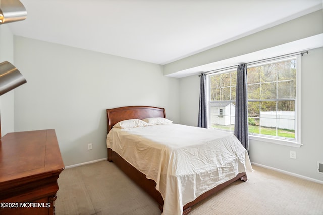 bedroom with carpet floors, multiple windows, and baseboards