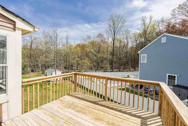 deck featuring a fenced backyard, an outbuilding, a yard, and a shed