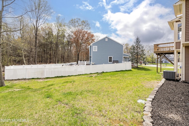 view of yard with central AC unit, fence, and a deck