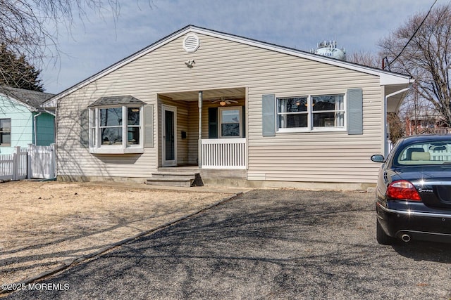 bungalow-style home with fence and covered porch