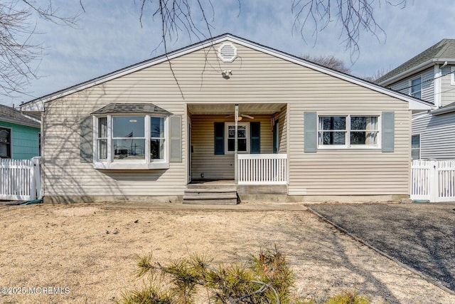 bungalow featuring a porch, fence, and ceiling fan