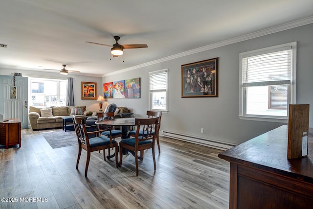 dining room featuring crown molding, wood finished floors, and a baseboard radiator