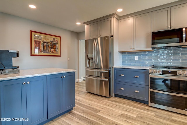 kitchen featuring blue cabinets, light wood-type flooring, recessed lighting, stainless steel appliances, and decorative backsplash