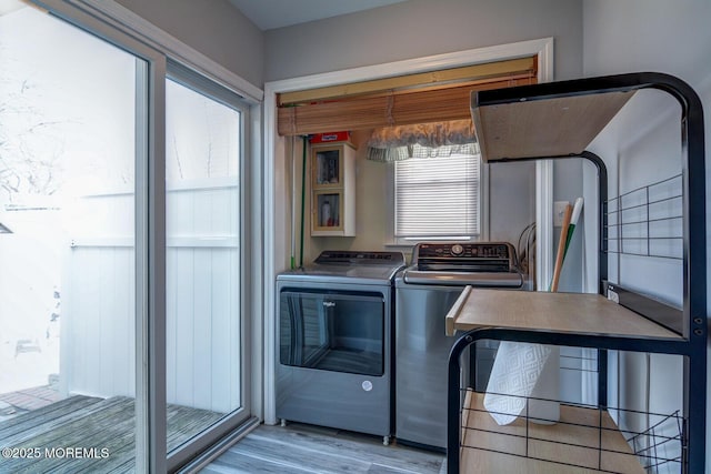 laundry area featuring laundry area, separate washer and dryer, and light wood finished floors