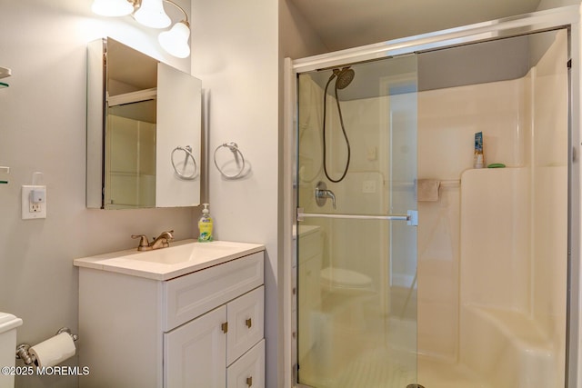 bathroom featuring vanity, toilet, and a stall shower