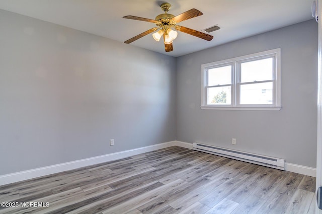 empty room with a ceiling fan, visible vents, baseboards, light wood-style floors, and a baseboard heating unit