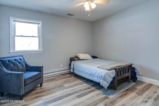 bedroom featuring visible vents, ceiling fan, baseboards, wood finished floors, and a baseboard radiator